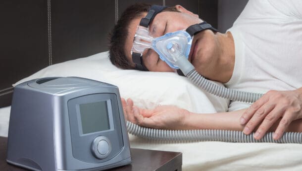 Mężczyzna, który śpi z podłączonym urządzeniem do CPAP