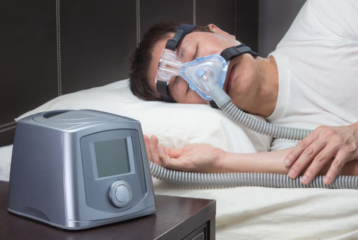 Mężczyzna, który śpi z podłączonym urządzeniem do CPAP